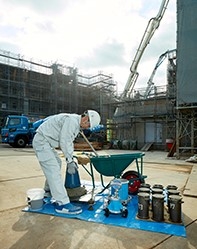 人が工場でコンクリートを配合している図